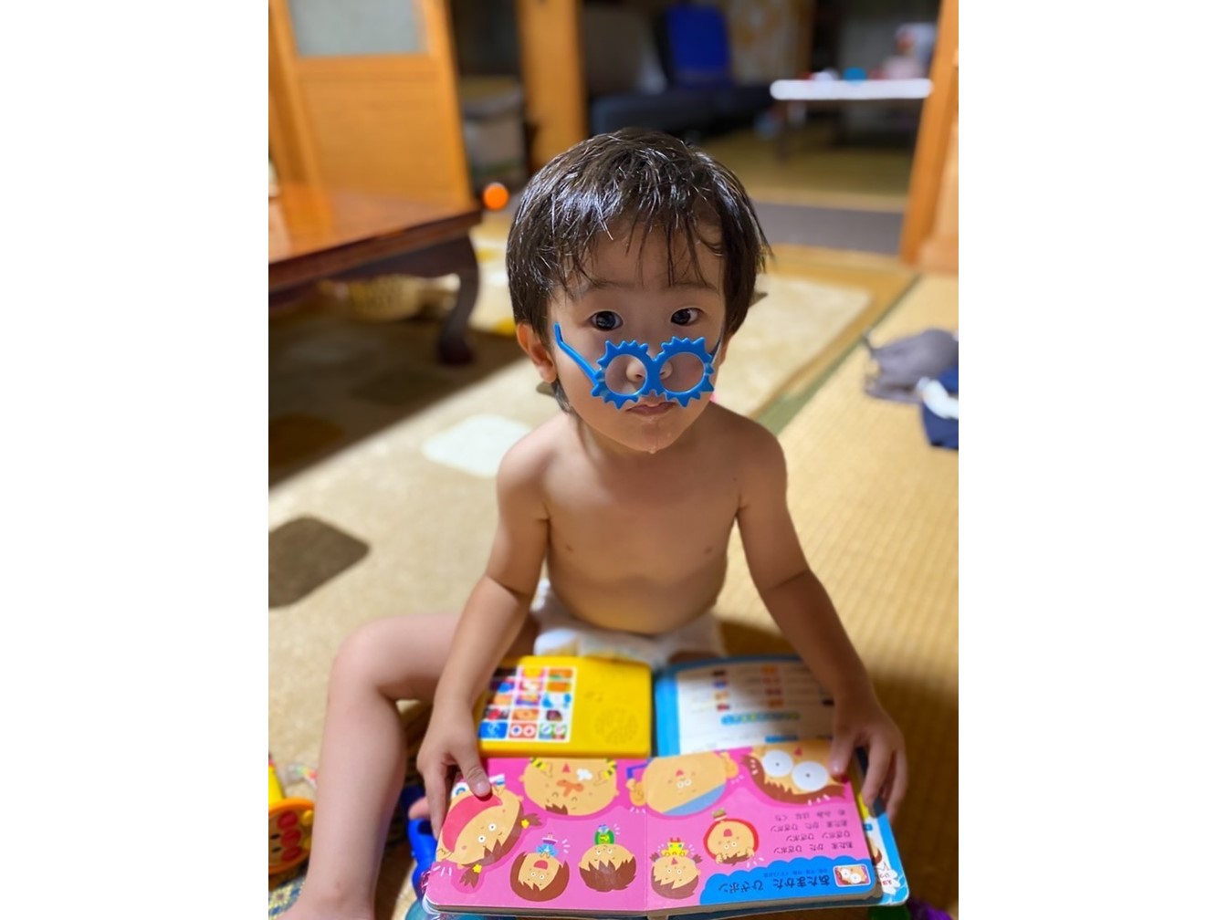 おうちフォトコンの写真を送ります！２歳の息子がお風呂あがりにおもちゃのメガネをかけて絵本を読んでいます。初めて自分でメガネをかけたんですが、逆さまなのが、かわいいポイントです(^^)